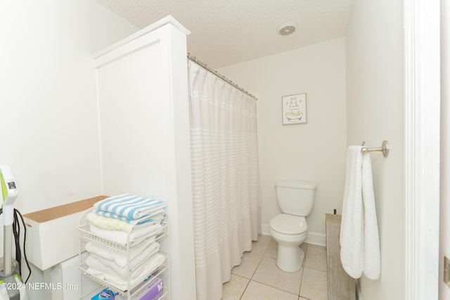 bathroom featuring toilet, tile patterned flooring, a textured ceiling, and walk in shower