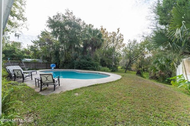 view of swimming pool featuring a patio area and a yard