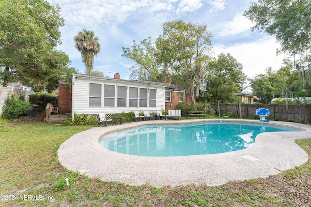 view of pool with a yard