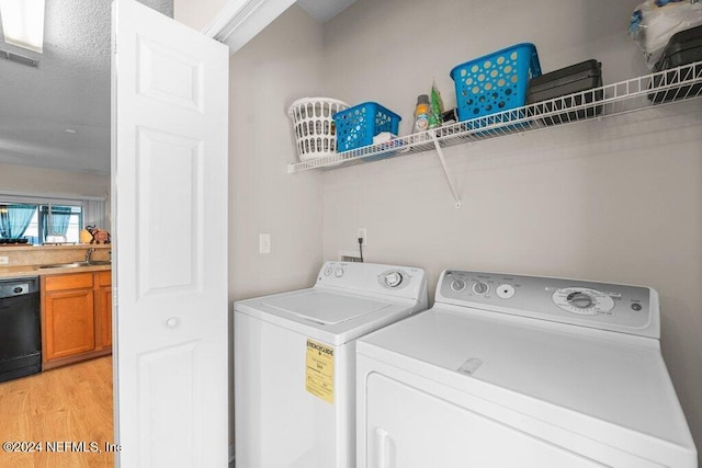 washroom with washing machine and dryer and light hardwood / wood-style flooring