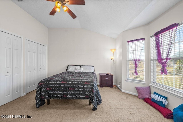 bedroom with multiple windows, ceiling fan, light carpet, and lofted ceiling