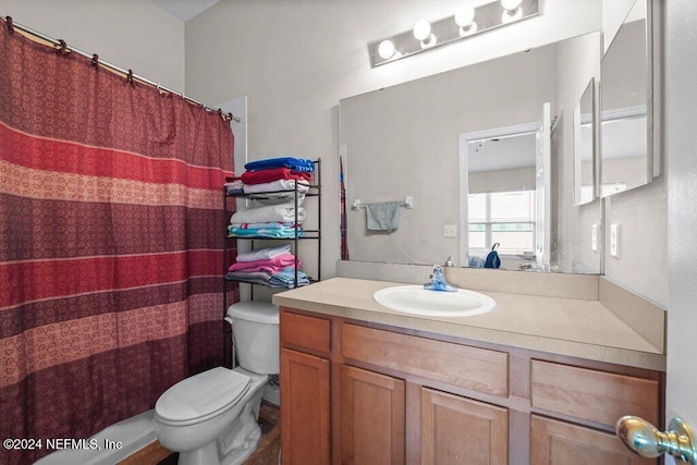 bathroom with hardwood / wood-style floors, vanity, a shower with shower curtain, and toilet