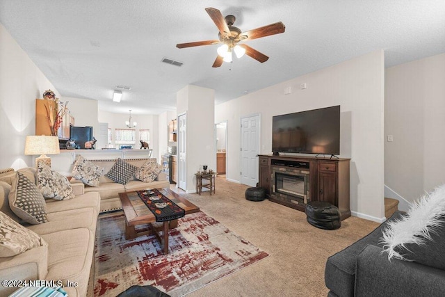 living room with a textured ceiling, light colored carpet, and ceiling fan with notable chandelier