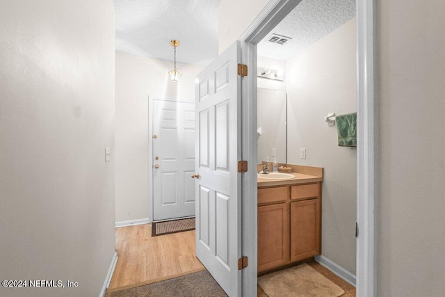 bathroom featuring vanity, a textured ceiling, and hardwood / wood-style flooring