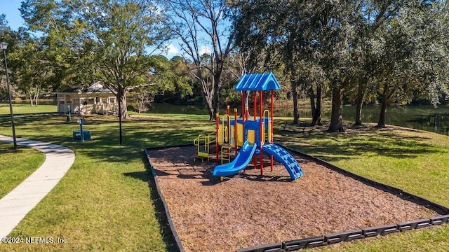 view of playground with a lawn and a water view