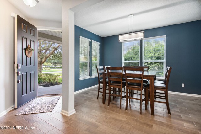 dining space featuring a wall mounted air conditioner and hardwood / wood-style floors