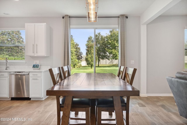 dining space featuring light hardwood / wood-style flooring, plenty of natural light, and sink