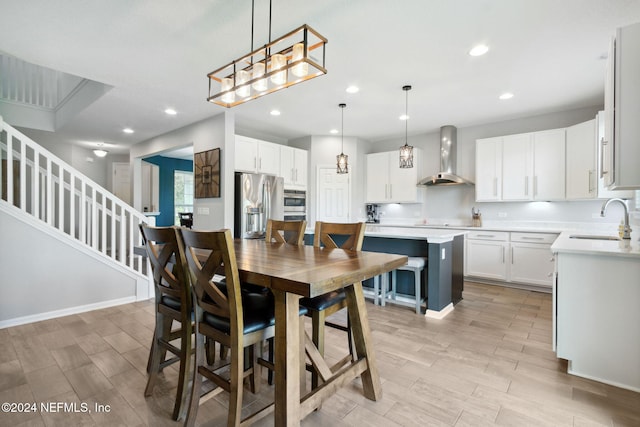 dining space with sink and light hardwood / wood-style flooring