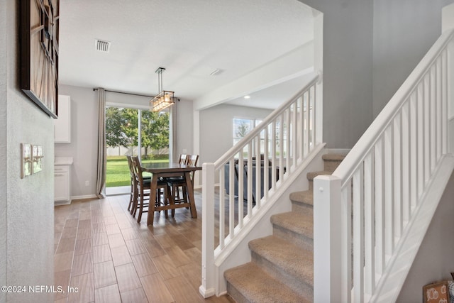 stairway with a wealth of natural light and wood-type flooring