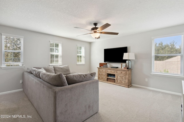 carpeted living room with ceiling fan and a textured ceiling