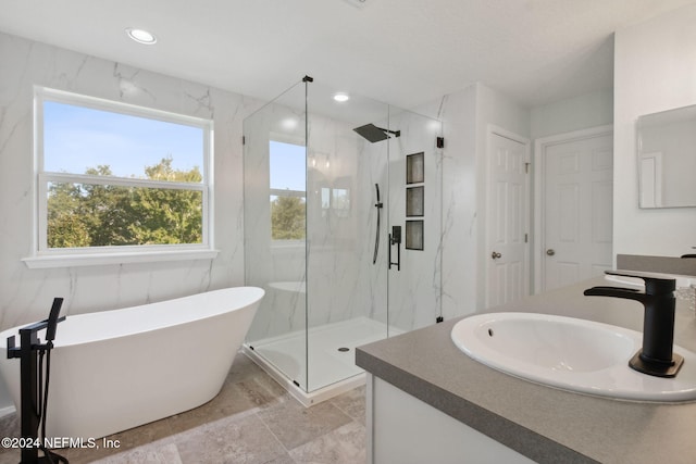 bathroom featuring shower with separate bathtub and vanity