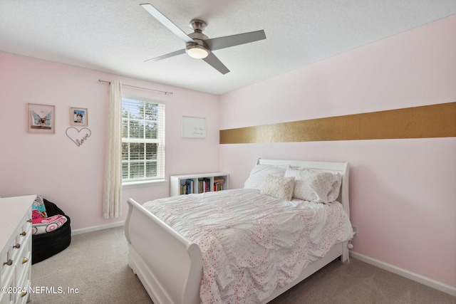 carpeted bedroom featuring ceiling fan and a textured ceiling