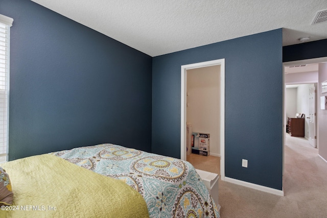 bedroom with light carpet and a textured ceiling