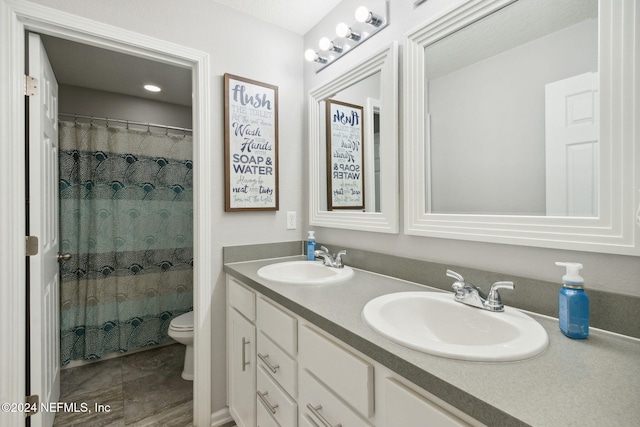 bathroom featuring curtained shower, vanity, and toilet