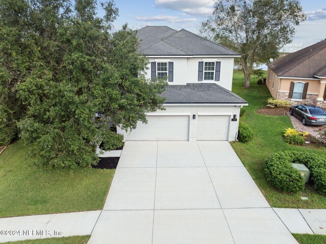 view of front of property with a garage and a front lawn