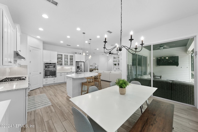 dining space featuring light hardwood / wood-style floors and a notable chandelier