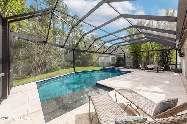 view of swimming pool featuring glass enclosure, an in ground hot tub, a patio, and a storage shed