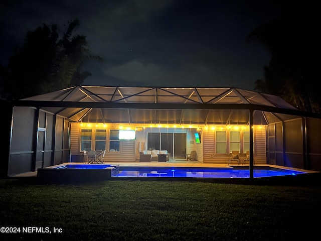 rear view of house featuring glass enclosure, a patio area, a yard, and an outdoor hangout area