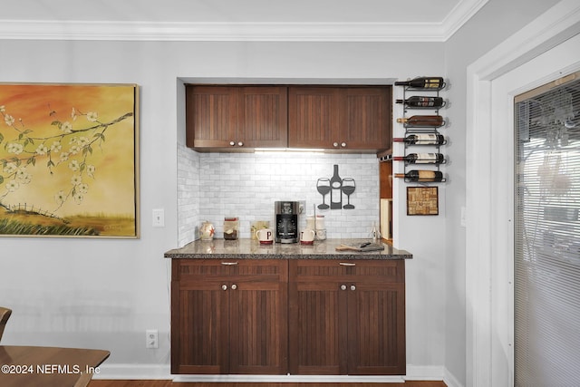 bar with wood-type flooring, backsplash, ornamental molding, and dark stone countertops