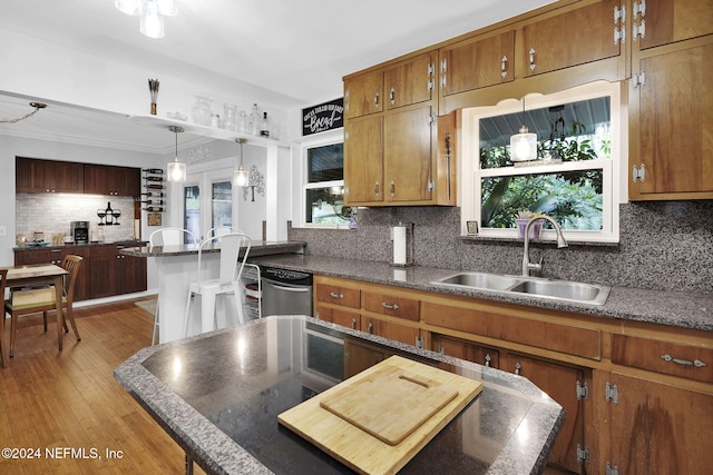 kitchen with backsplash, sink, a wealth of natural light, and light hardwood / wood-style flooring