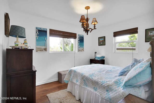 bedroom featuring dark wood-type flooring and an inviting chandelier