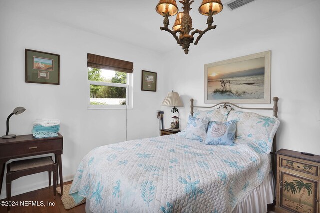 bedroom featuring dark hardwood / wood-style floors and a notable chandelier