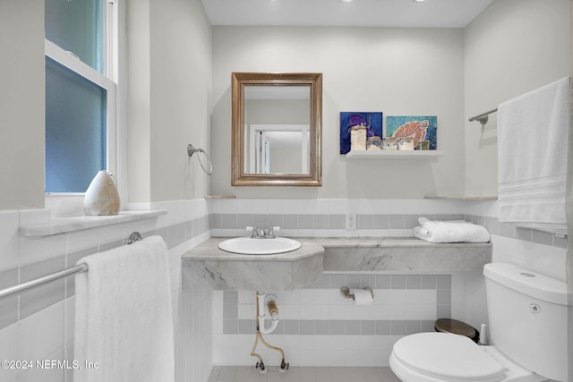 bathroom featuring sink, tile patterned flooring, tile walls, and toilet