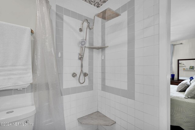 bathroom with toilet and a shower with shower curtain