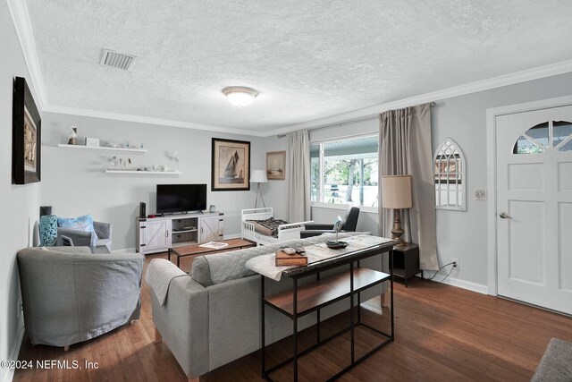 living room featuring a textured ceiling, ornamental molding, and dark wood-type flooring