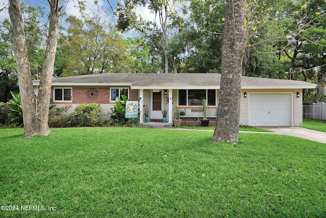 ranch-style house featuring a front lawn, covered porch, and a garage