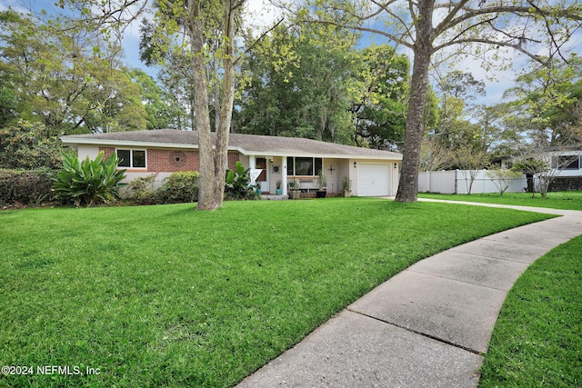 ranch-style home with a garage and a front lawn