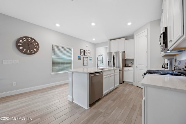 kitchen with a center island with sink, white cabinets, light wood-type flooring, and appliances with stainless steel finishes