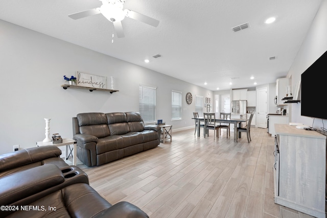 living room with ceiling fan and light hardwood / wood-style floors