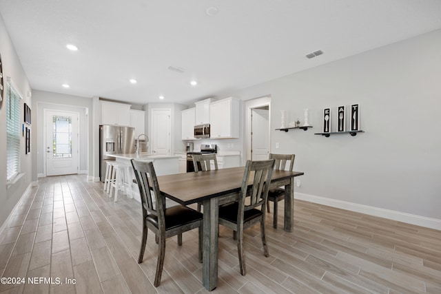 dining area with light hardwood / wood-style floors and sink