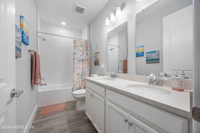 full bathroom featuring hardwood / wood-style flooring, shower / bath combination with curtain, toilet, and vanity