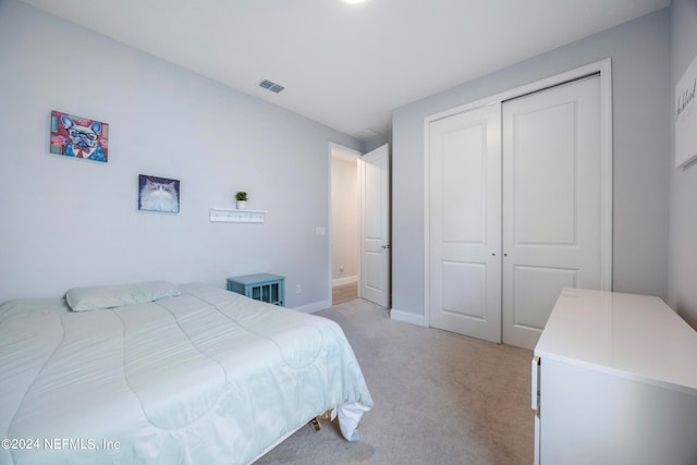 bedroom featuring light colored carpet and a closet