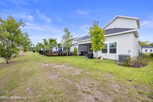 view of yard with central AC unit and a sunroom