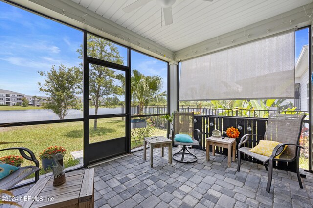 sunroom / solarium featuring ceiling fan and a water view