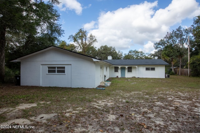 rear view of house featuring a lawn