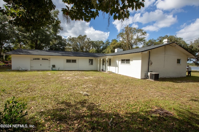 rear view of property featuring central AC and a yard