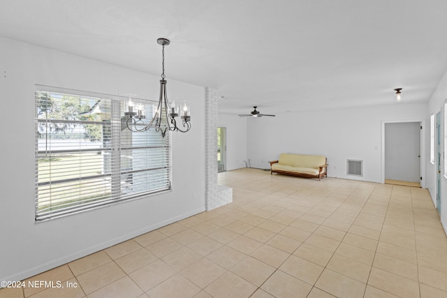 unfurnished dining area featuring ceiling fan with notable chandelier and light tile patterned floors