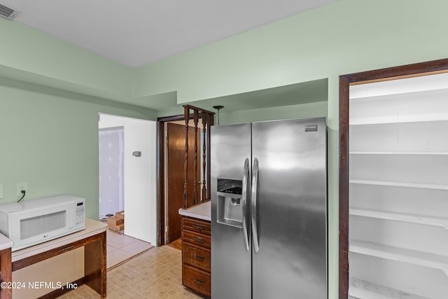 kitchen featuring stainless steel fridge with ice dispenser