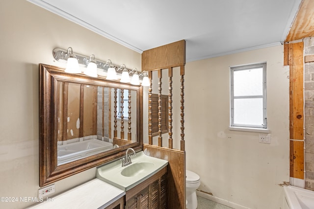 bathroom featuring a tub to relax in, toilet, vanity, and ornamental molding