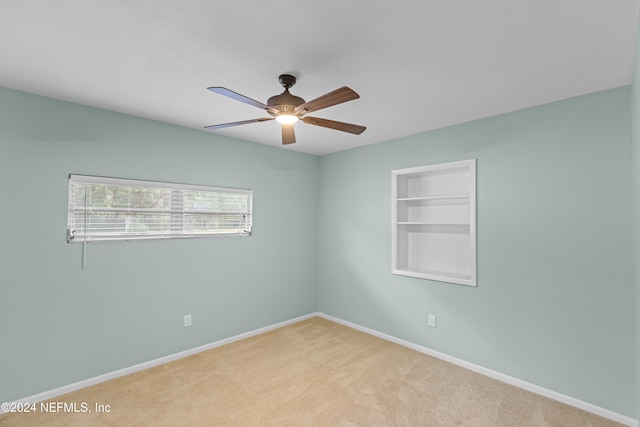 spare room with light carpet and ceiling fan