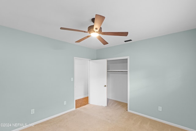 unfurnished bedroom featuring ceiling fan, light colored carpet, and a closet