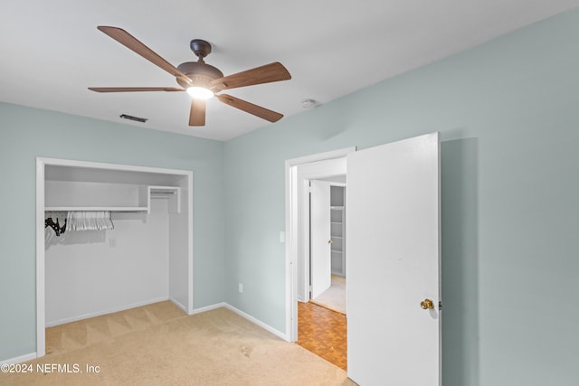 unfurnished bedroom featuring ceiling fan, a closet, and light carpet