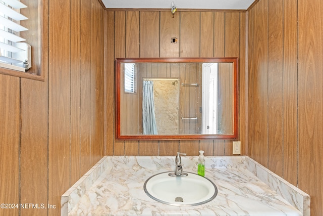 bathroom with vanity and wooden walls