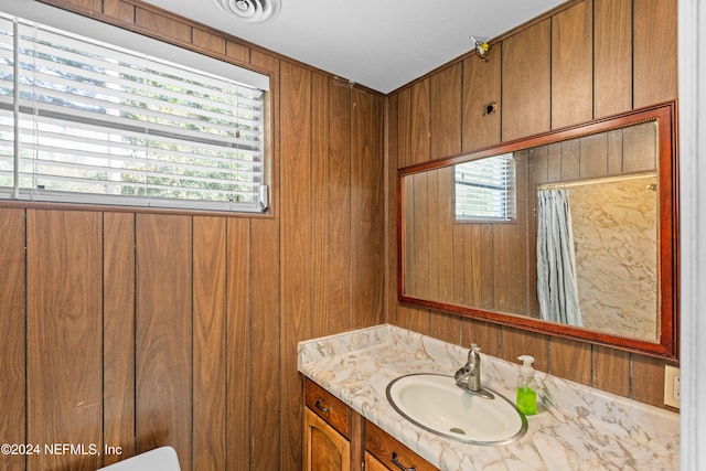 bathroom featuring wooden walls and vanity