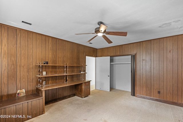 office space with ceiling fan, wood walls, and light carpet