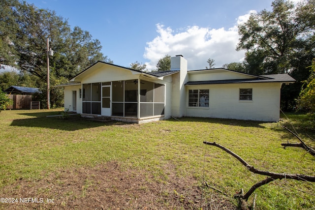 back of house with a lawn and a sunroom